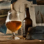 Bière normande en verre tulipe sur table bois